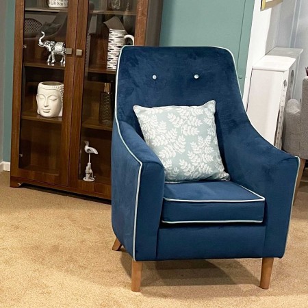 Rona mid back contract chair in lounge setting in blue fabric with white piping